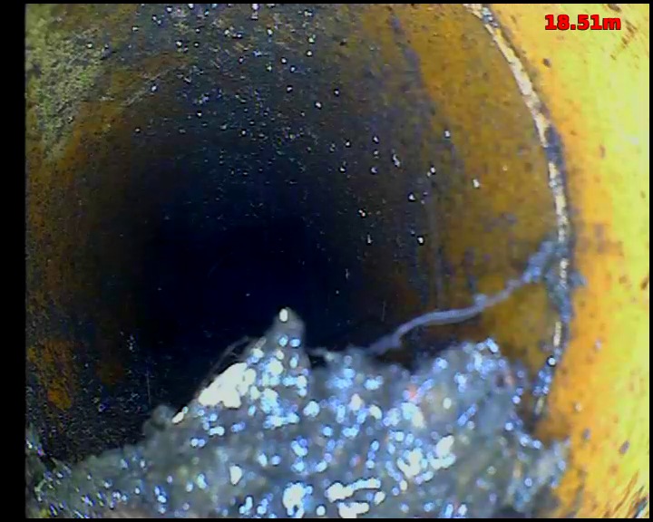 CCTV view inside a drain showing loose debris collected against the pipe wall